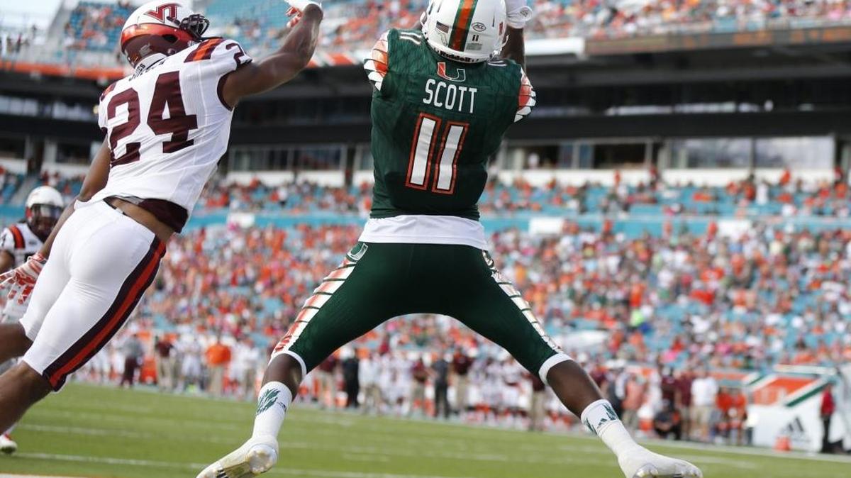
El wide receiver de los Huracanes Rashawn Scott (11) anota un touchdown, el sábado.
