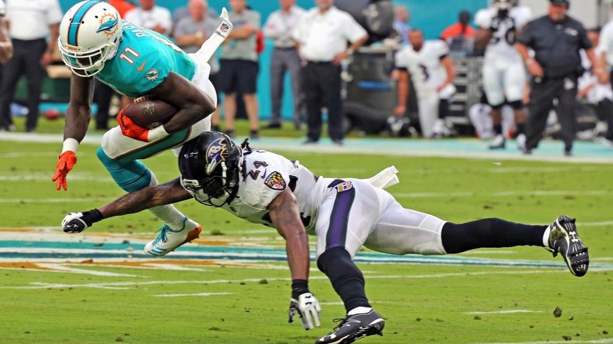 DeVante Parker (11), de los Dolphins, es frenado por Brandon carr (24), de los Ravens, en el Hard Rock Stadium, el jueves 17 de agosto del 2017.