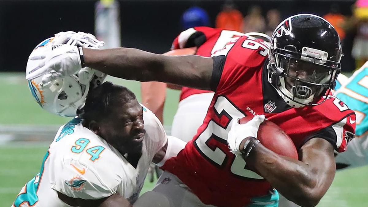 El linebacker de los Dolphins Lawrence Timmons (izq.) derriba al running back de los Falcons DeAndre Washington, en un partido efectuado el 15 de octubre de 2017 en Atlanta.