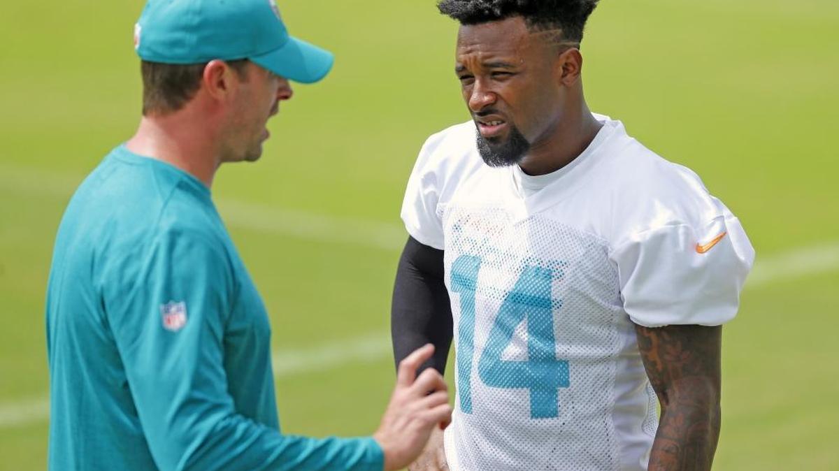 El entrenador Adam Gase conversa con el wide receiver Jarvis Landry (14) durante el minicampamento de entrenamiento de los Dolphins, en junio pasado.