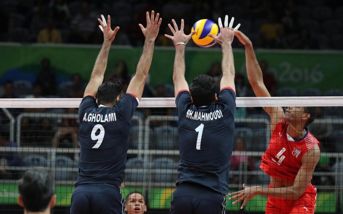 Los jugadores iraníes de voleibol Adel Gholami (#9) y Shahram Mahmoudi (#1) bloquean el balón ante un ataque del cubano Javier Jimenez Scull, el jueves 11 de agosto de 2016 en el Arena indoor Maracanazinho de Río de Janeiro, Brasil.