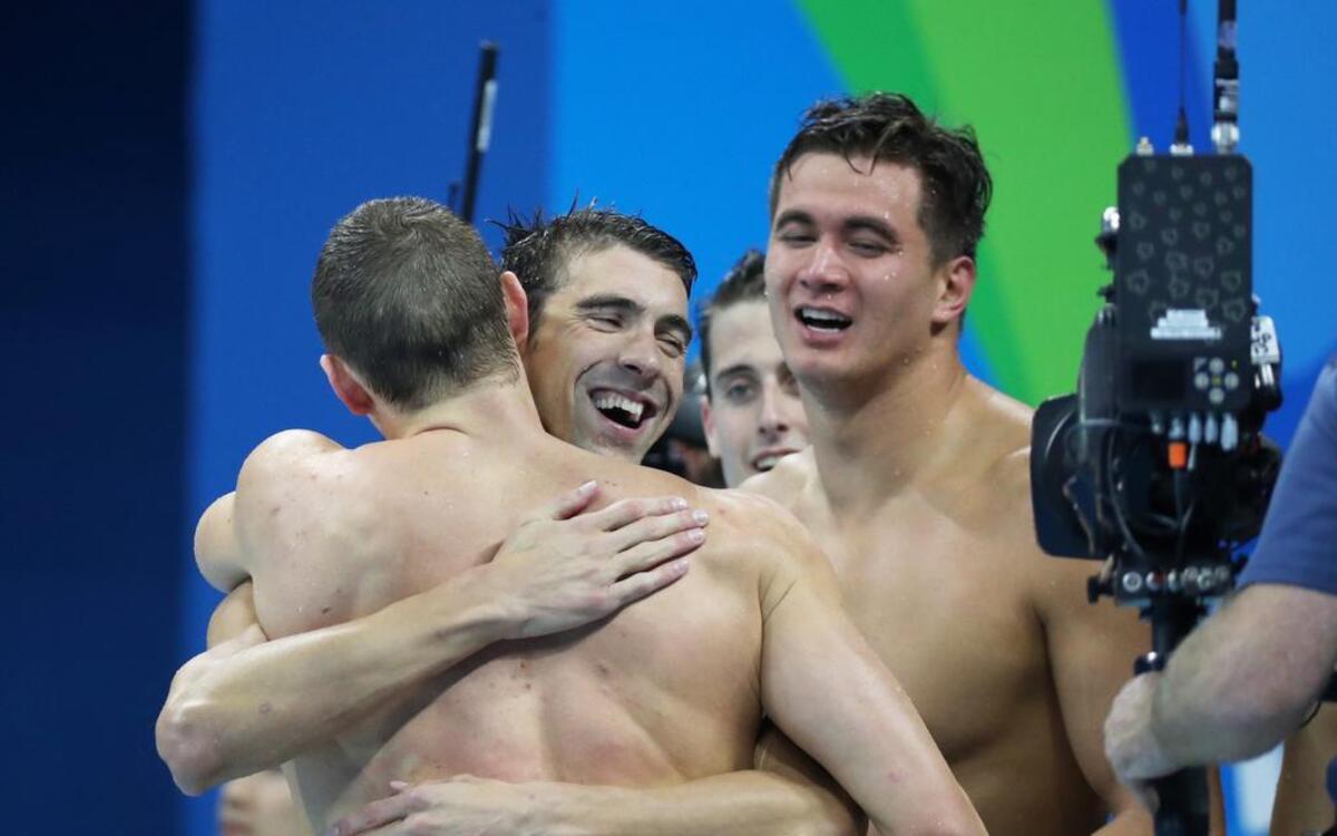 El estadounidense Michael Phelps (centro) es felicitado por sus compañeros tras ganar la prueba de natación de relevo 4x100 metros combinada, el sábado 13 de agosto de 2016, durante las Olimpiadas de Río 2016, en el estadio Acuático Olímpico de Río de Janeiro (Brasil).