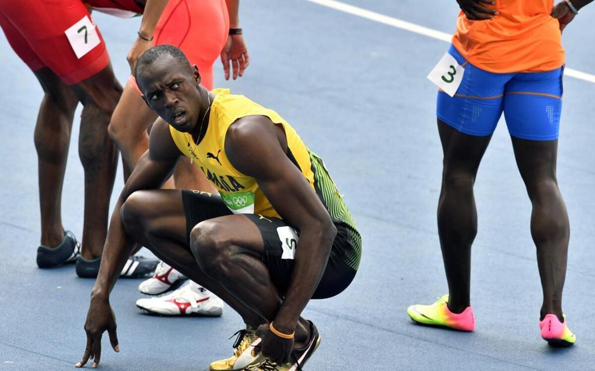 Usain Bolt se quita las zapatillas tras ganar una carrera eliminatoria de los 200 metros planos, el 16 de agosto del 2016, en Río de Janeiro.