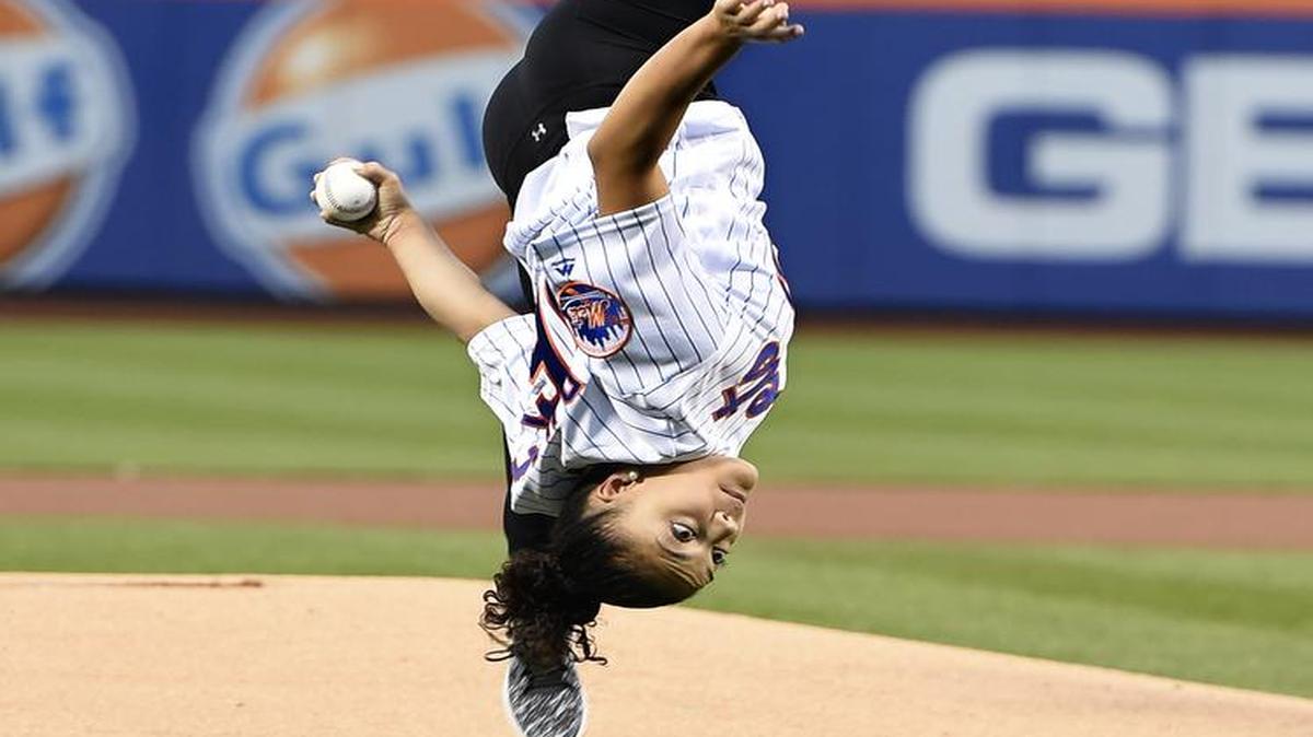 La medallista olímpica de oro Laurie Hernández da una voltereta en la lomita antes de lanzar la primera bola en el juego entre los Mets y los Nacionales, el sábado 3 de septiembre del 2016, en New York.