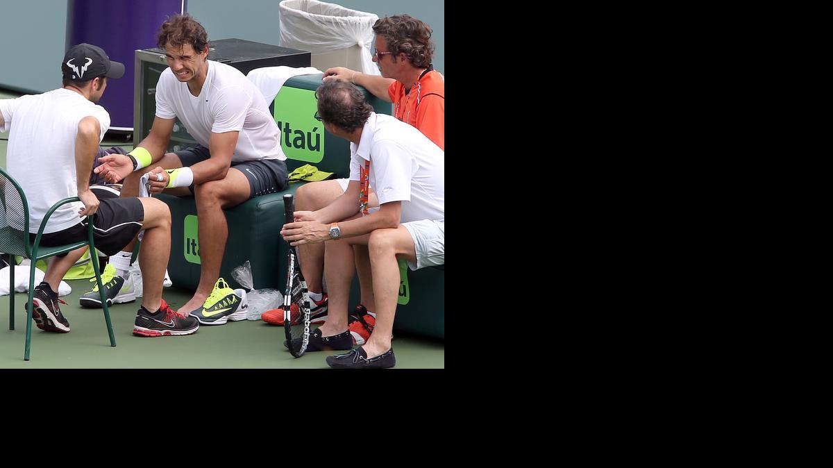 
Rafael Nadal hace un gesto de dolor mientras conversa con los integrantes de su equipo luego de haberse torcido el pie izquierdo en una práctica con el búlgaro Grigor Dimitrov, el lunes en el estadio principal del Miami Open.
