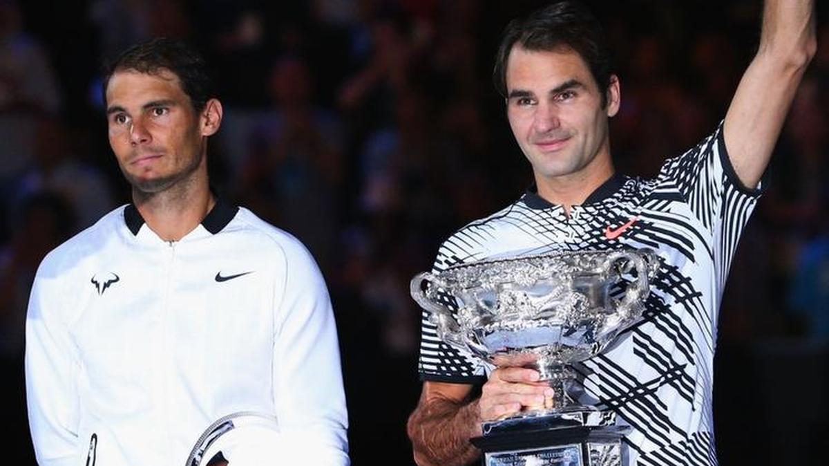 El tenista número dos del mundo, Rafa Nadal (izq.), y Roger Federer, el número uno, posan con sus respectivos trofeos tras jugar la final del Abierto de Australia el 29 de enero del 2017.