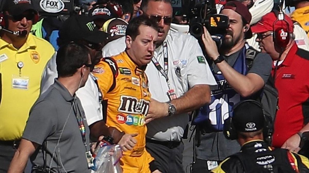 Kyle Busch, piloto del coche #18 M&M's Toyota, con la frente ensangrentada, es retirado por autoridades de NASCAR luego del incidente en pits con Joey Logano (no aparece en la foto), del #22 Pennzoil Ford, al término de la Monster Energy NASCAR Cup Series Kobalt 400 en el Autódromo de Las Vegas, el domingo 12 de marzo del 2017 en Las Vegas, Nevada. Los coches de Busch y Logano hicieron contacto en la pista en la última vuelta, lo que provocó la pelea.
