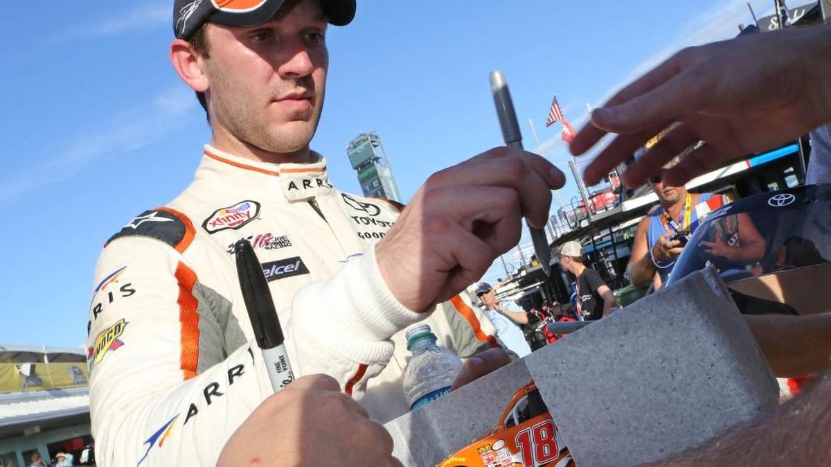 El mexicano Daniel Suárez firma autógrados luego de la práctica del viernes para la carrera del sábado en Homestead.