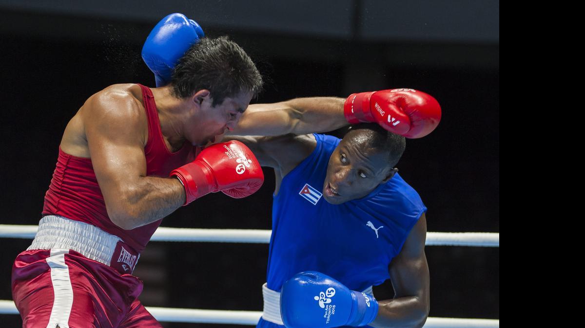 
Miguel Véliz (i) de Chile y el cubano Erislandy Savón combaten en peso pesado hoy, miércoles 22 de julio de 2015, durante el torneo de boxeo de los Juegos Panamericanos de Toronto (Canadá). Savón ganó el combate de semifinales. 
