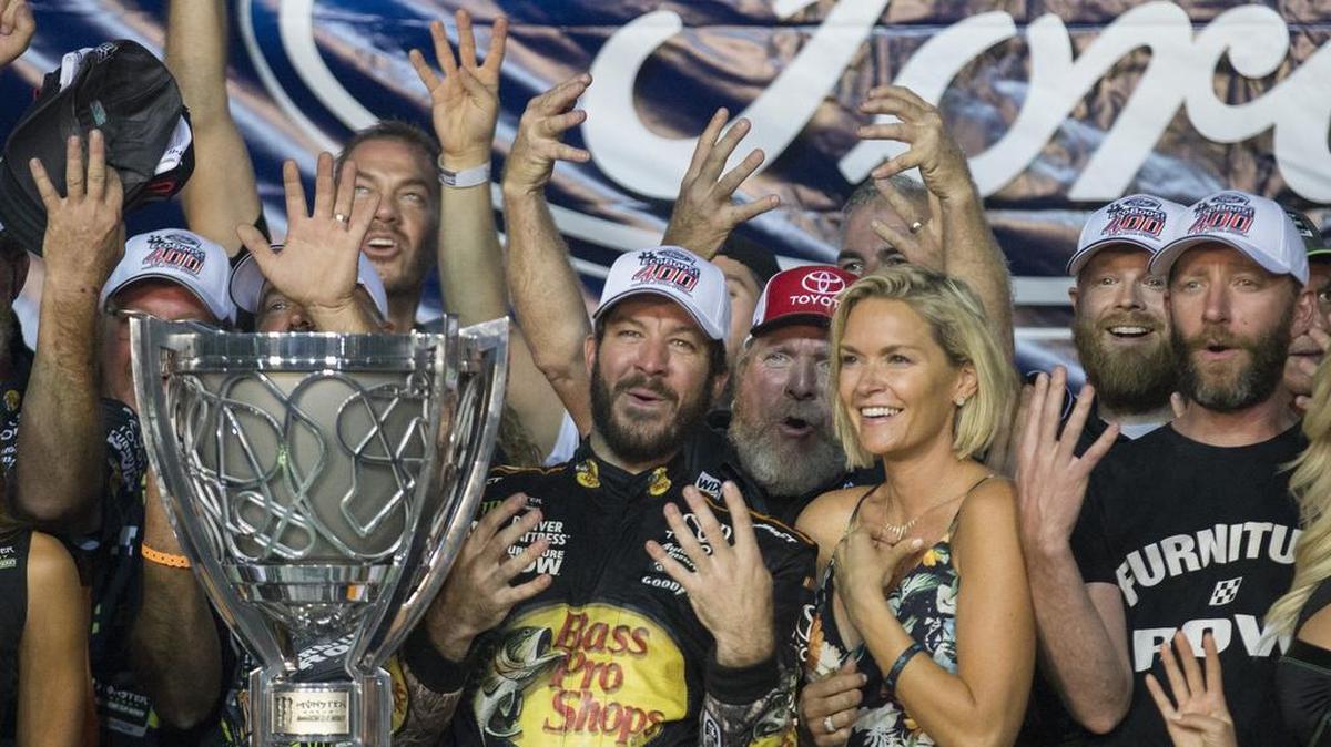 Martin Truex Jr. (centro) celebra con su esposa luego de ganar la Monster Energy Cup de NASCAR, el domingo 19 de noviembre del 2017 en Homestead.