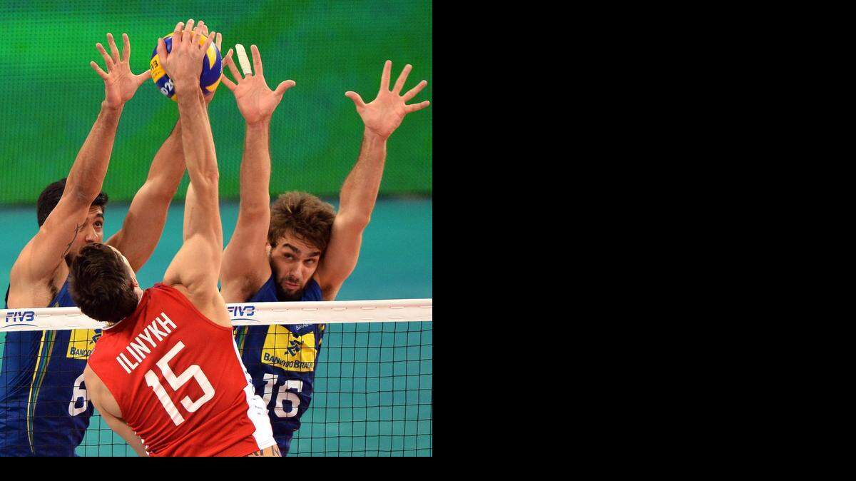 
Los jugadores de Brasil Leandro Vissotto (izq.) y Lucas Saatkamp bloquean el remate al ruso Dmitriy Ilinykh.
