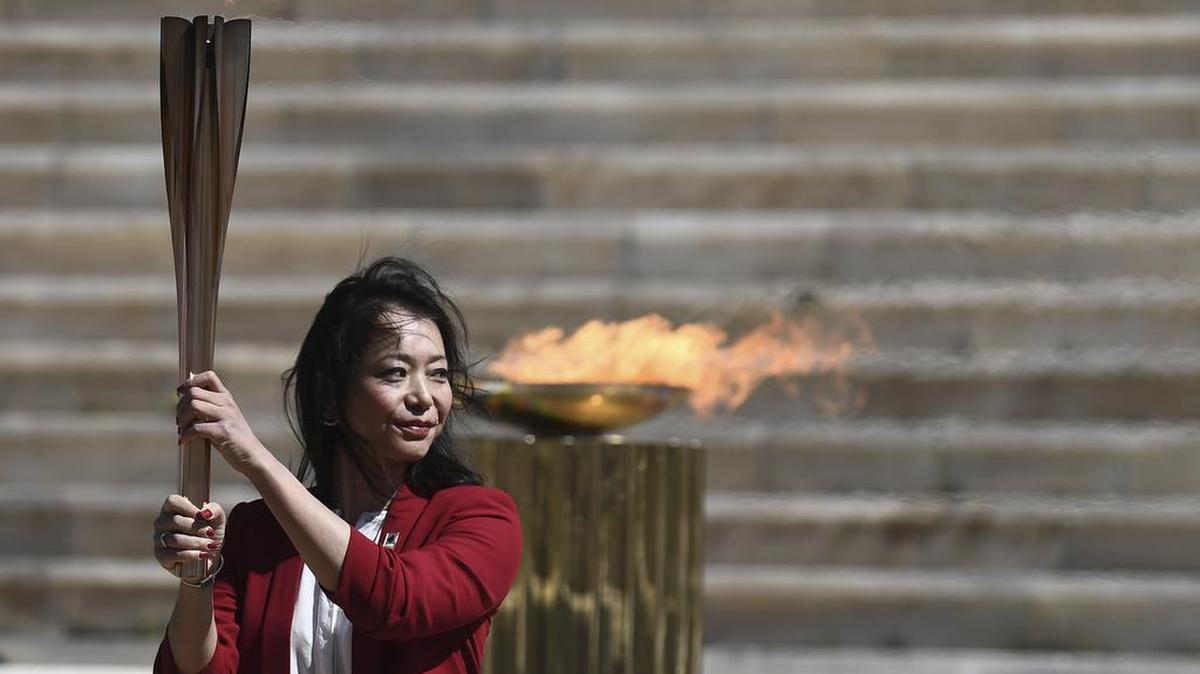 La exnadadora japonesa Imoto Naoko posa con la antorcha olímpica en la ceremonia de entrega de la llama para los Juegos de Tokio 2020, en Atenas, el 19 de marzo de 2020.