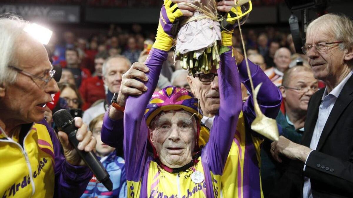 El aficionado francés de 105 años, Robert Marchand, sostiene un ramo de flores tras batir su propio récord de la hora en el velódromo de Saint-Quentin En Yvelines, cerca de París, Francia, el 4 de enero de 2017.
