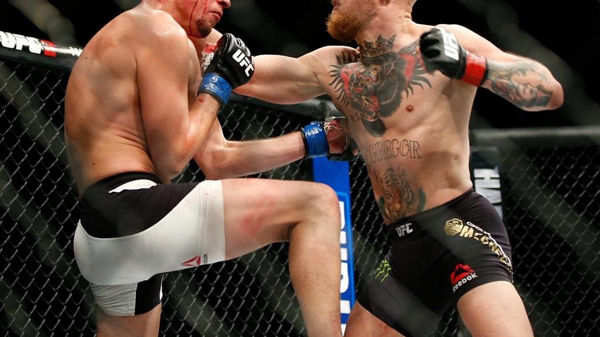 Conor McGregor (der.) cambia golpes con Nate Diaz en la pelea de peso welter en el UFC 196, en Las Vegas el 5 de marzo del 2016.