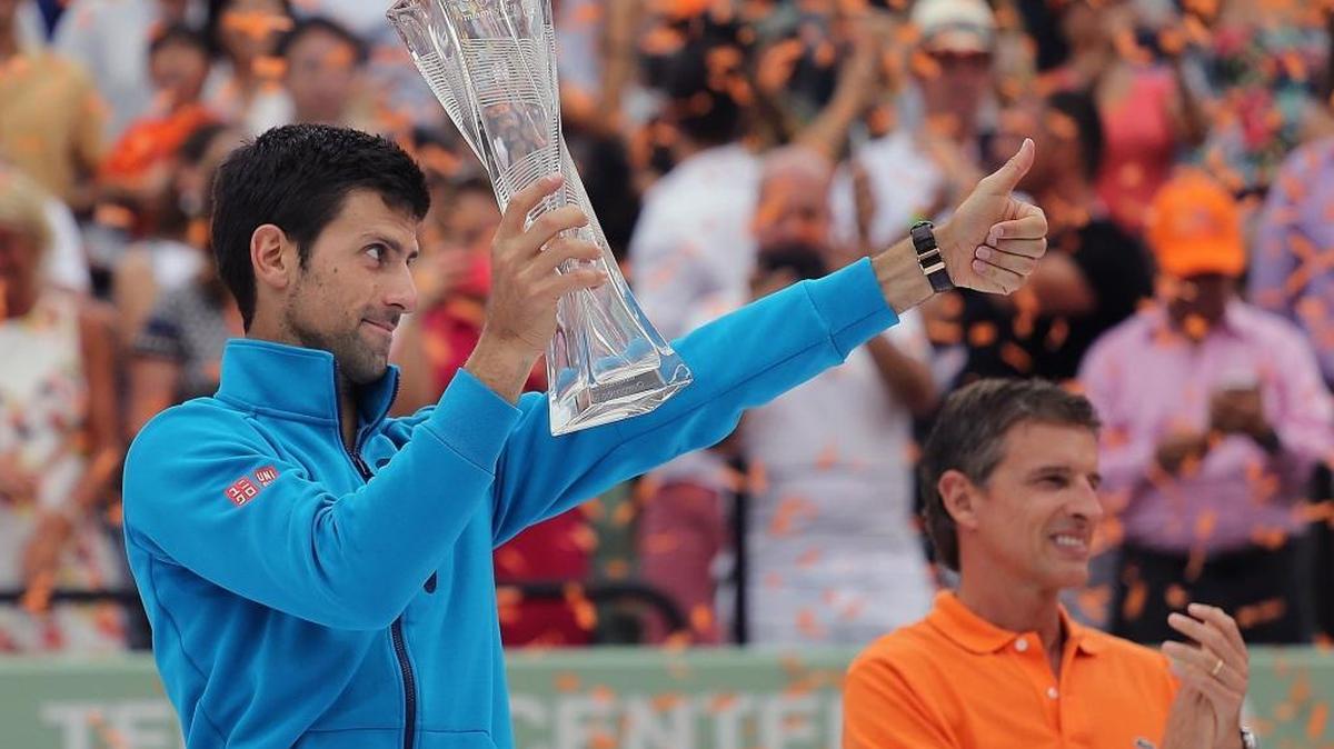 El serbio Novak Djokovic sostiene su trofeo y muestra a su equipo el dedo arriba luego de vencer 6-3, 6-3 al japonés Kei Nishikori, para conseguir su sexto Miami Open, el domingo 3 de abril del 2016 en Crandon Park Tennis Center en Key Biscayne, Florida.