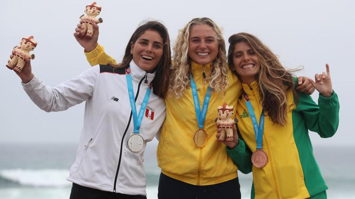 Isabella Gómez (centro) de Colombia, medalla de oro, posa junto a Vania Torres (izq.) de Perú, plata, y Nicole Pacelli de Brasil, bronce, este domingo 4 de agosto de 2019 en la premiación de surffemenino en los Juegos Panamericanos en Lima, Perú.