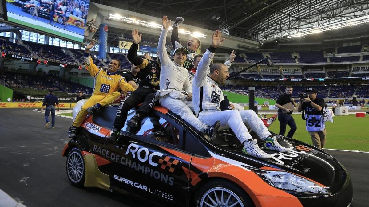 Juan Pablo Montoya (izq.), Felipe Massa (centro) y Tony Kanaan, pilotos latinoamericanos del equipo Resto del Mundo, dan una vuelta victoriosa en el cierre de la Carrera de Campeones en Marlins Park convertido en autódromo, el domingo.