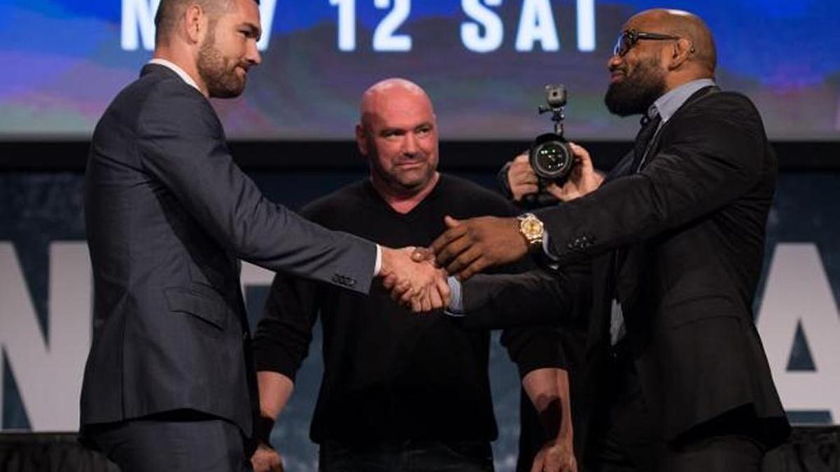 YOEL ROMERO (d) y Chris Weidman (i) se saludan mientras el presidente de la UFC, Dana White, los contempla.