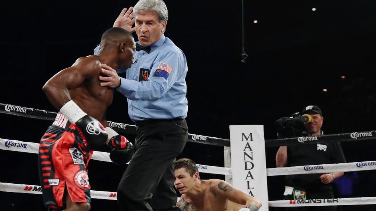 Guillermo Rigondeaux (izq.) es separado por el referee Vik Drakulich después de tumbar al boxeador mexicano Moisés Flores en el primer asalto, este sábado 17 de junio en Las Vegas.