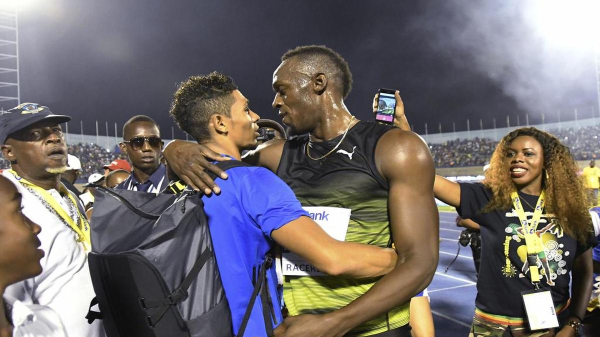  Wayde van Niekerk (centro) abraza a Usain Bolt en una carrera el 10 de junio del 2017 en Kingston, Jamaica.