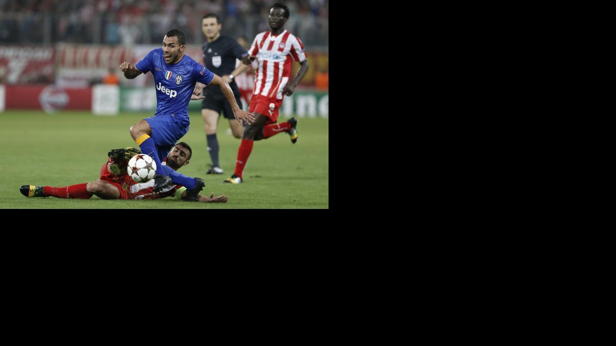 
El argentino de la Juventus Carlos Tevez trata de escapar del jugador de Olympiacos Ioannis Maniatis.


