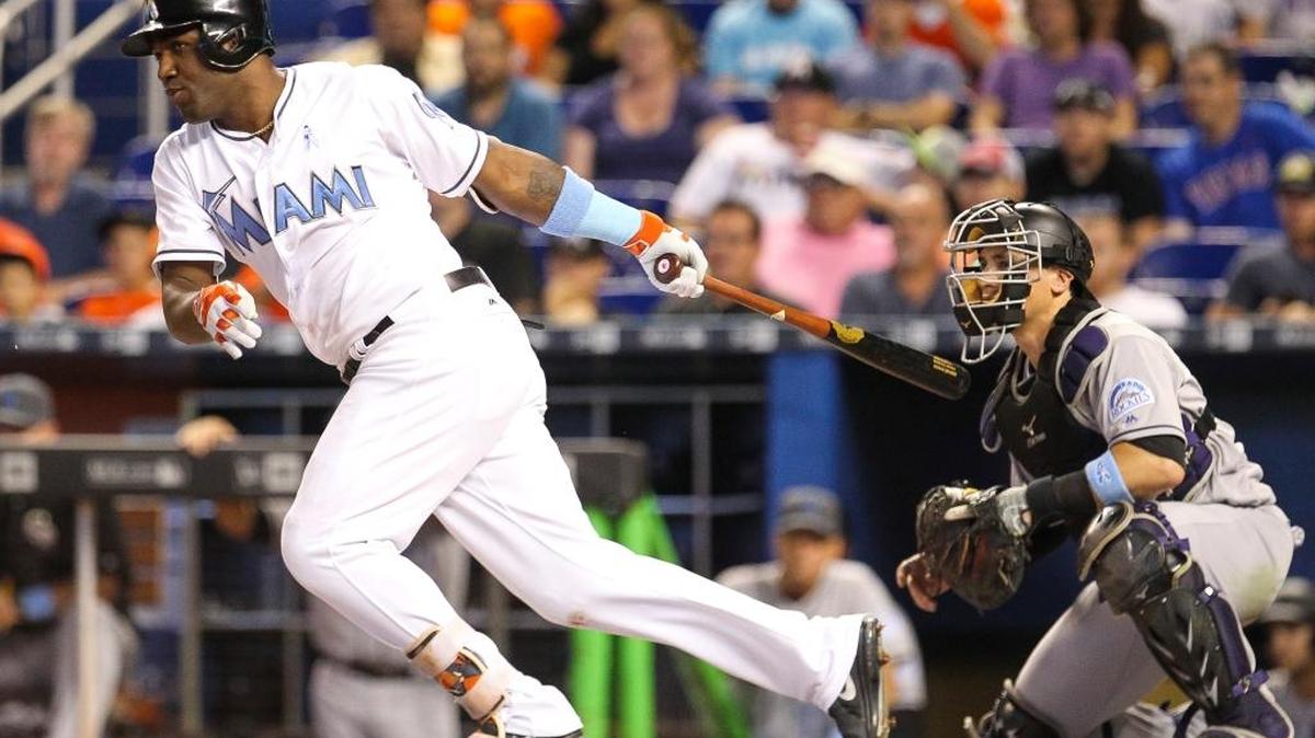 Marcell Ozuna, de los Marlins, conecta un sencillo en el segundo inning contra los Rockies, el domingo en Miami.