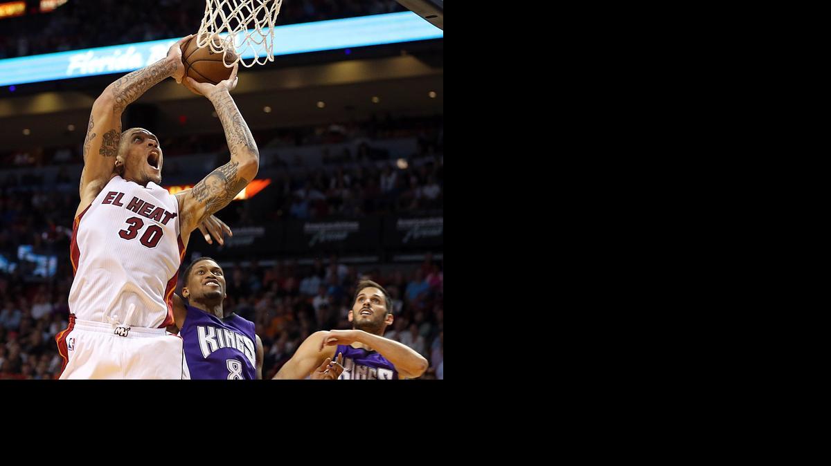 
Michael Beasley, del Heat, se dispone a encestar marcado por Rudy Gay (8), de los Kings, el sábado.
