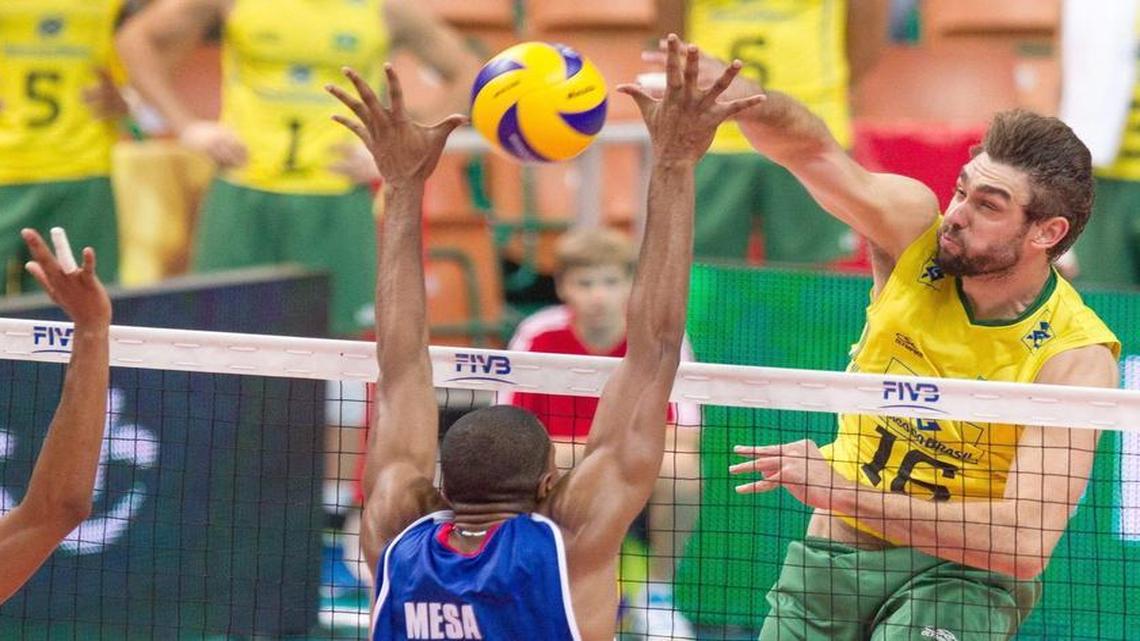 El jugador de Brasil Lucas Saatkamp (der.) de Brasil remata a la pelota ante el bloqueo de los cubanos Isbel Mesa Sandoval (cen.) y Osmany Santiago Uriarte, durante un partido del Campeonato de Voleibol FIVB el 4 de julio del 2014.