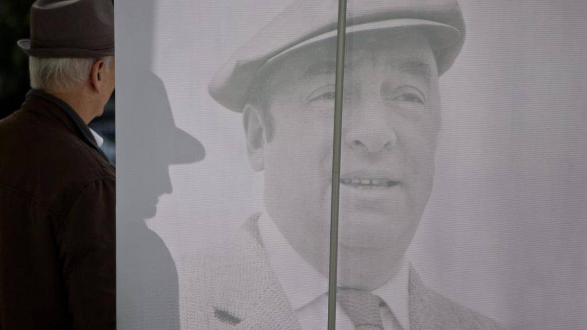 Un hombre posa con una foto del célebre poeta ganador del Premio Nobel, Pablo Neruda, durante un homenaje público el 25 de abril en Santiago de Chile.