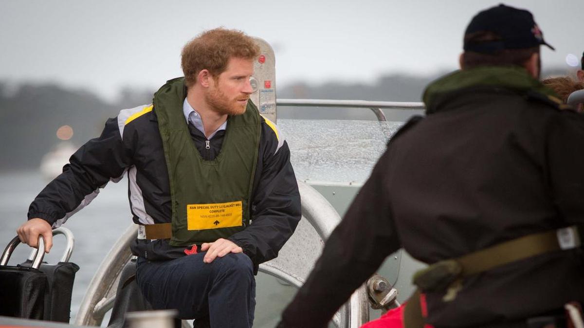 Una foto distribuida por la marina de guerra australiana real del príncipe Harry hablando con competidores de los juegos de Invictus 2018 alrededor del puerto de Sydney el 7 de junio de 2017.
