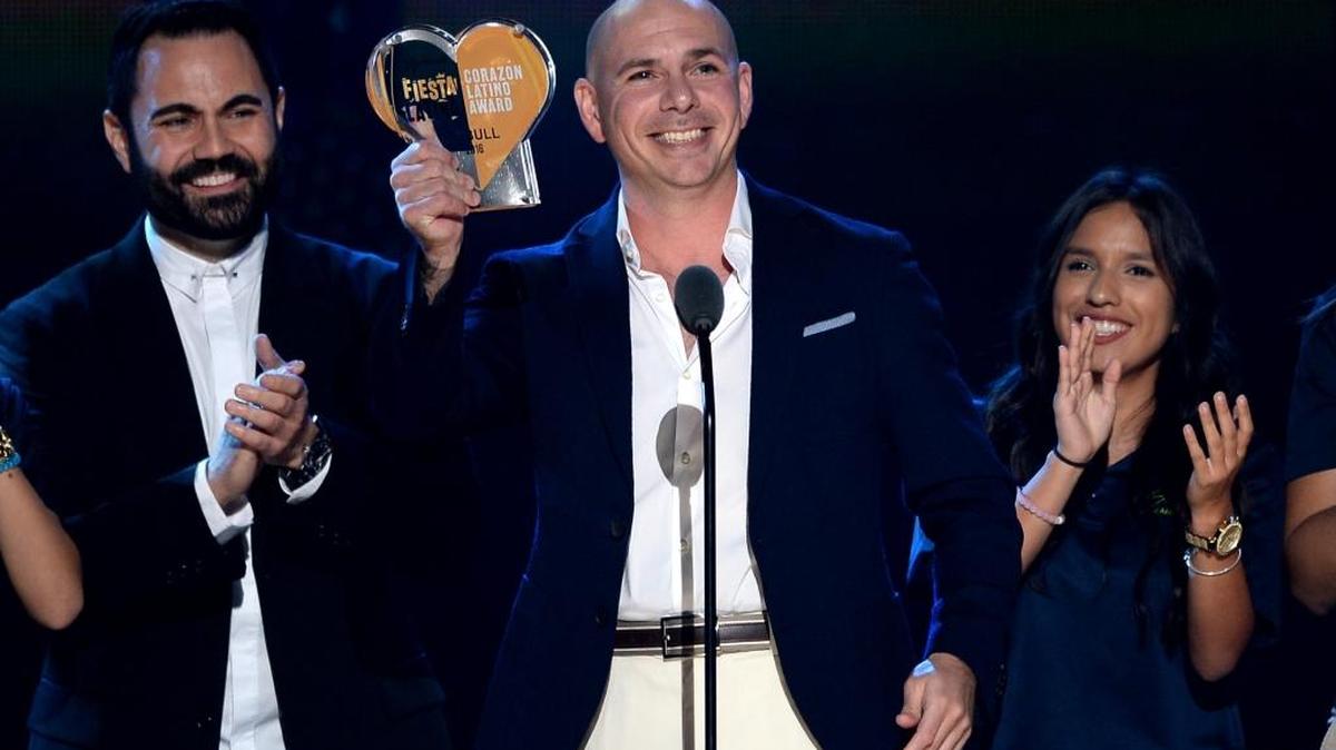 Enrique Santos (izq.) entrega el sábado el premio Fiesta Latina Corazón Latino a Pitbull, en el American Airlines Arena.