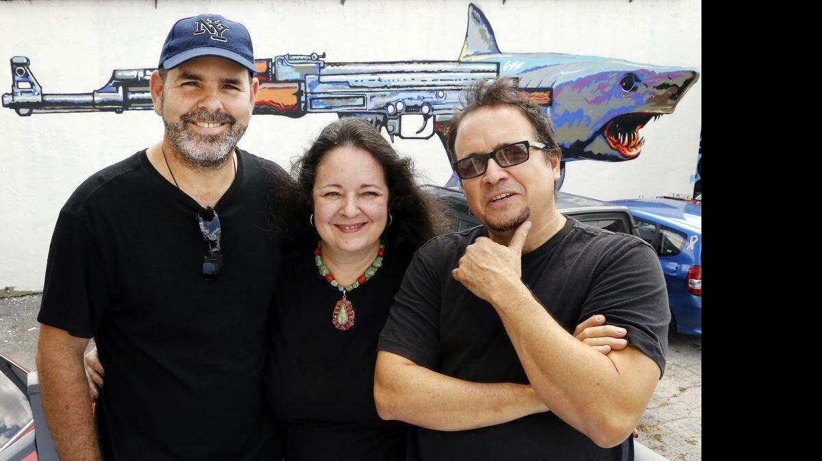 
Los pintores Ismael Gómez Peralta, Ana María Sarlat y Néstor Arenas frente a el mural ‘AKMako’ pintado por Arenas en el Bird Road Art District.
