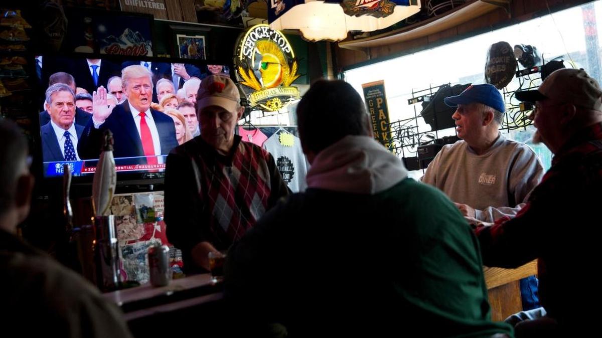 De izq. q der.: Denny Riebe, Doug Dickman, Scott Reilly y Bill Winter, en Sawmill Saloon en Prairie du Chien, tienen como fondo la toma de posesión del presidente Donald Trump en trasmisión en vivo en la TV, el 20 de enero.