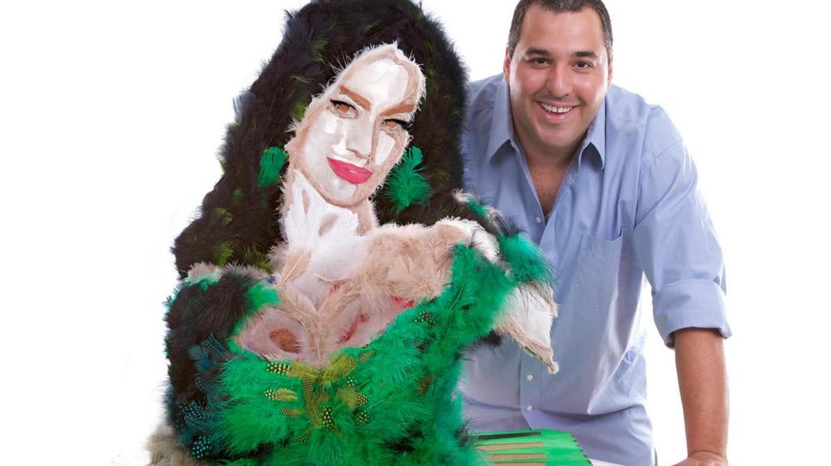 Fotografía cedida que muestra al artista colombiano Mateo Blanco posando junto a su escultura de la actriz colombiana Sofía Vergara hecha con plumas de colores. Debido a las pulgas, la actriz colombiana Sofía Vergara casi se queda sin ser retratada por su compatriota Mateo Blanco, un artista que realiza sus obras con objetos y elementos de la naturaleza como dados, maníes o chocolate.
