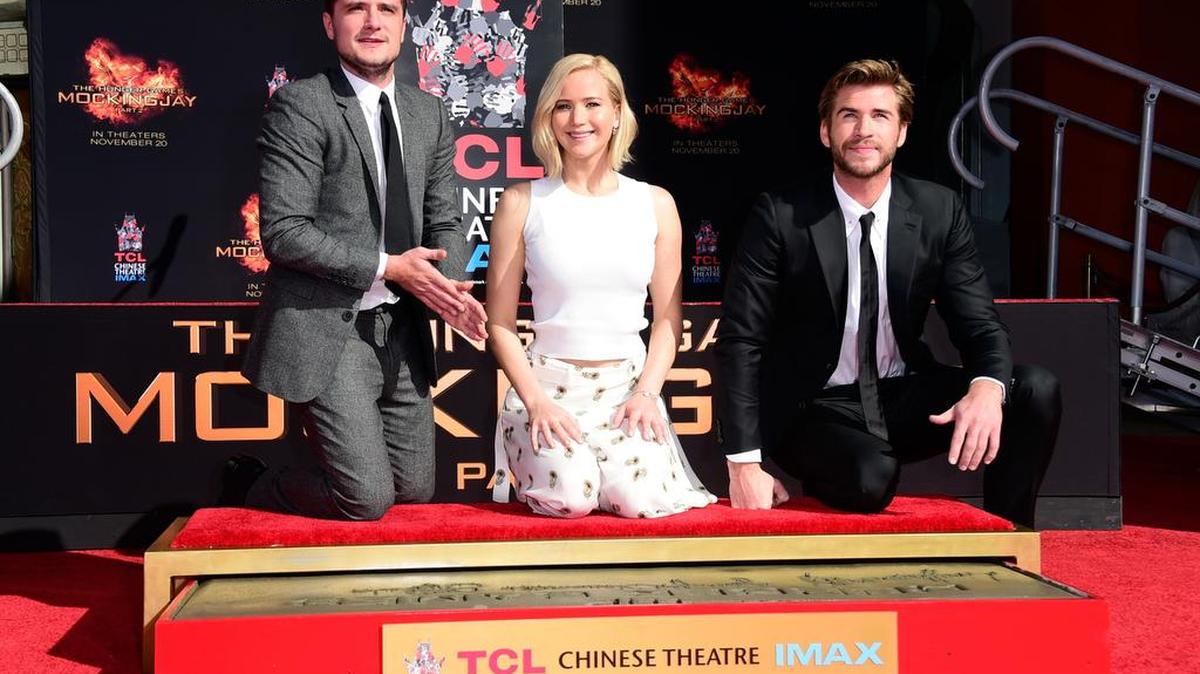 Los actores Josh Hutcherson, Jennifer Lawrence y Liam Hemsworth atienden a la ceremonia de huellas de manos y pies en el teatro chino TCL este viernes 31 de octubre de 2015 en Hollywood, California.