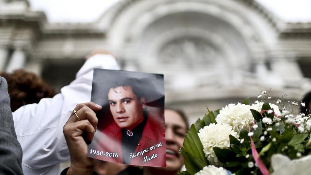 Una mujer sostiene una foto de Juan Gabriel el domingo 4 de septiembre de 2016, en el Palacio de Bellas Artes en Ciudad de México (México).