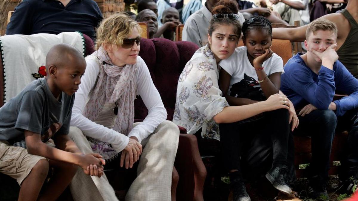 Esta foto de archivo tomada el 2 de abril de 2013 muestra a la estrella pop estadounidense Madonna, sentada con sus hijos biológicos y adoptados David Banda, Lourdes, Mercy James y Rocco en la Escuela Primaria Mkoko, en la región de Kasungu, en el centro de Malawi.
