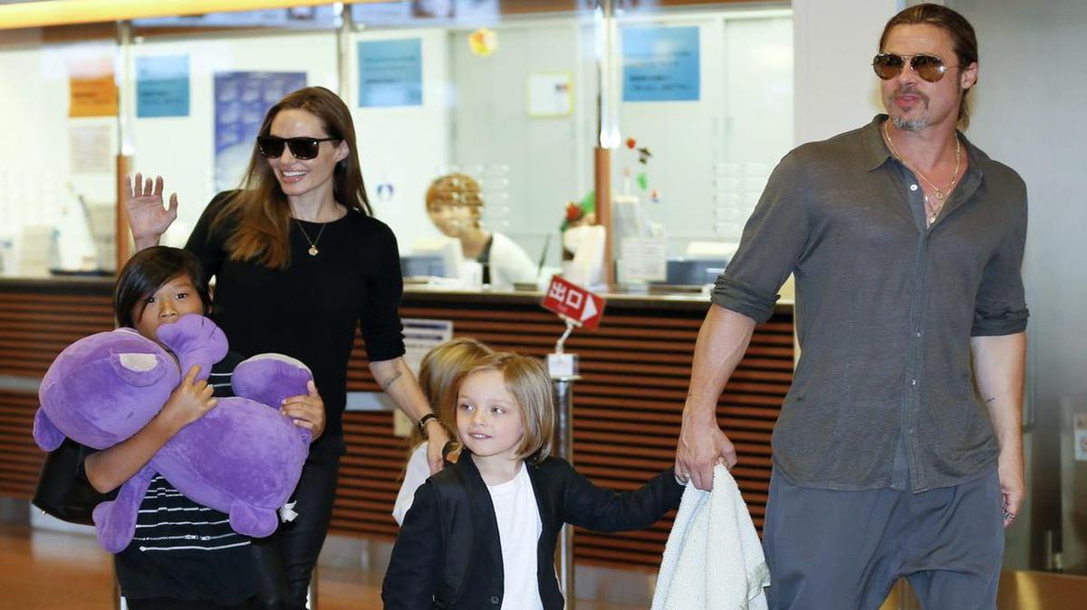 Fotografía de archivo tomada el 28 de julio de 2013 muestra a la actriz Angelina Jolie (2i) y al actor Brad Pitt (d) junto a sus hijos Pax Thien (i), Shiloh (3i, tapada) y Knox (2d) a su llegada al aeropuerto Haneda en Tokio (Japón). Los actores Angelina Jolie y Brad Pitt alcanzaron un acuerdo sobre la custodia de sus seis hijos dentro de las negociaciones para resolver su divorcio.