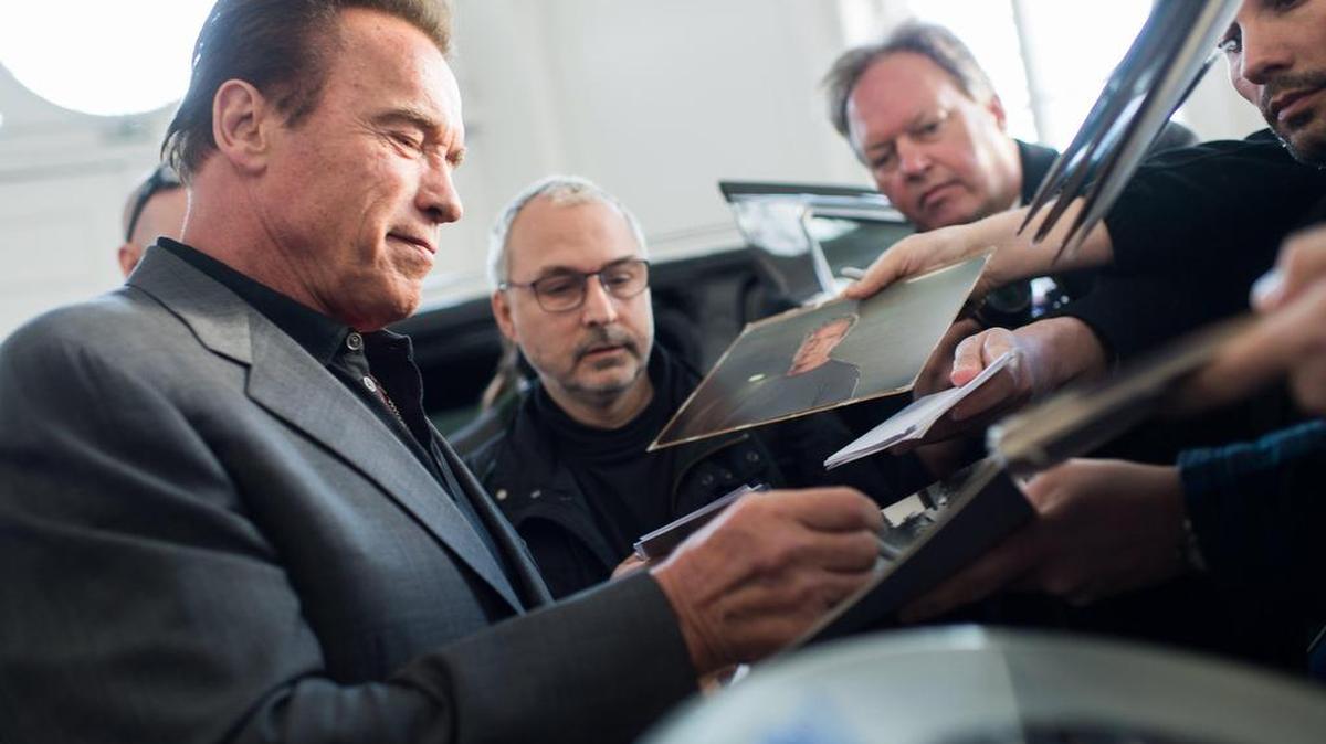 El actor y exgobernador de California, Arnold Schwarzenegger, firma autógrafos después de reunirse con el presidente austríaco Alexander Van der Bellen el sábado en Viena.