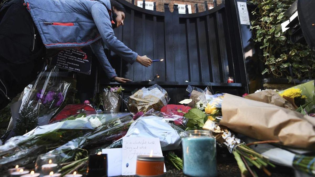 ARA2 LONDRES (REINO UNIDO), 26/12/2016.- Una mujer enciende una vela frente a la vivienda del cantante británico George Michael en Londres, Reino Unido, el 26 de diciembre de 2016. Michael falleció en su casa de Goring, Oxfordshire, a los 53 años de edad.