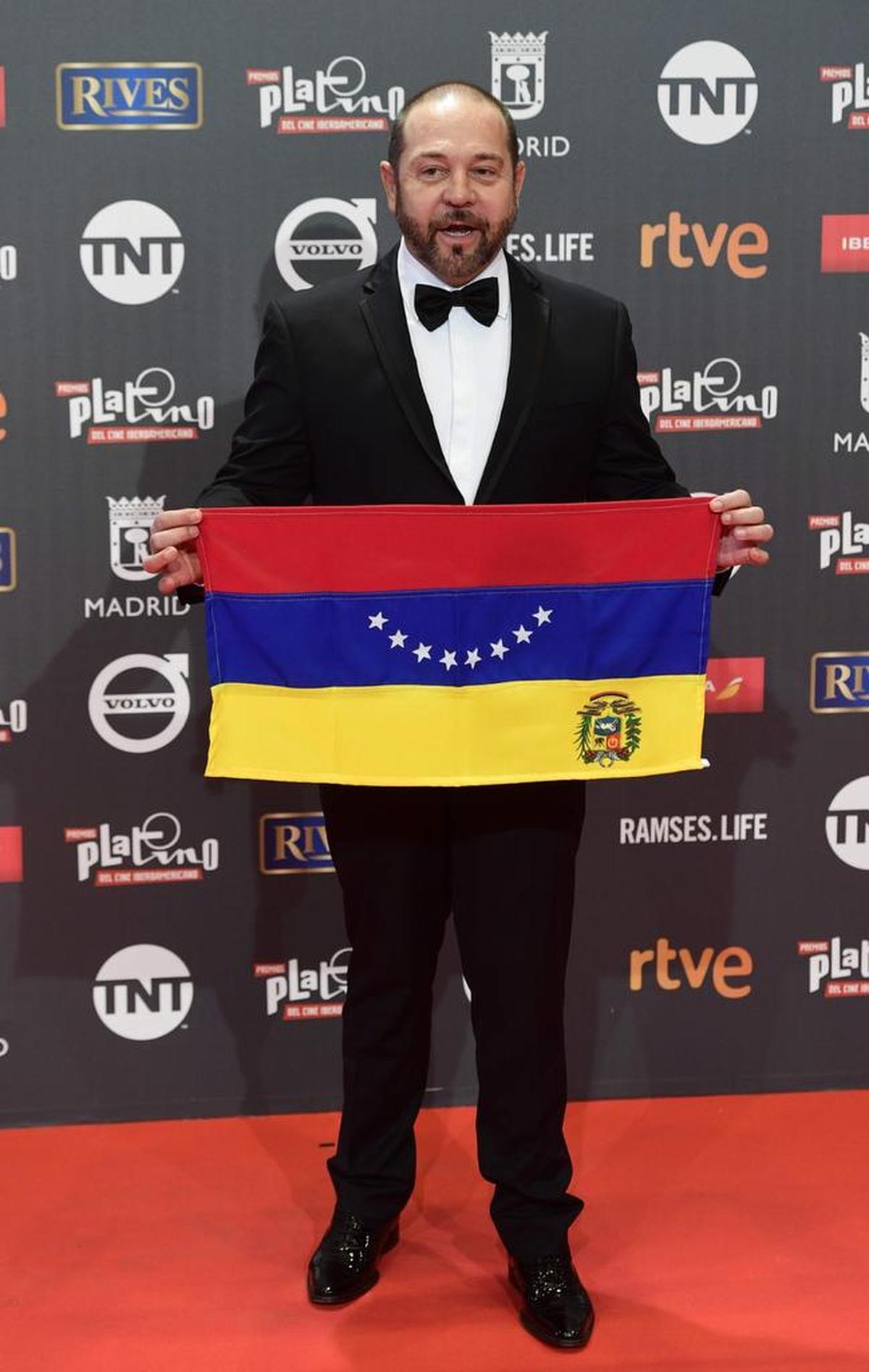 El director de Venezuela, Miguel Ferrari, exhibe una bandera en la alfombra roja durante la 4ª edición de los Premios Platino para la entrega de premios del Cine Iberoamericano en Madrid el 22 de julio de 2017.