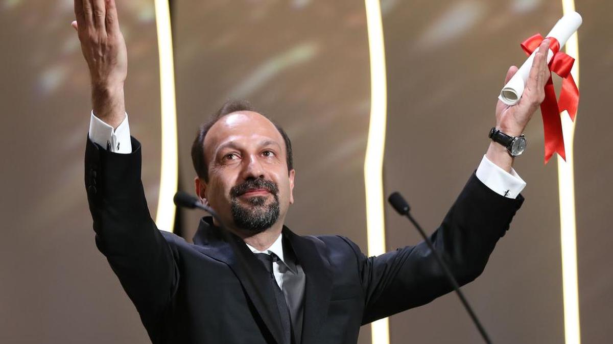 El director iraní director Asghar Farhadi celebra tras recibir el premio a mejor guión por la película “El Viajeante”, durante la edición 69 del Festival de Cine de Cannes, en Francia, el 22 de mayo de 2016.