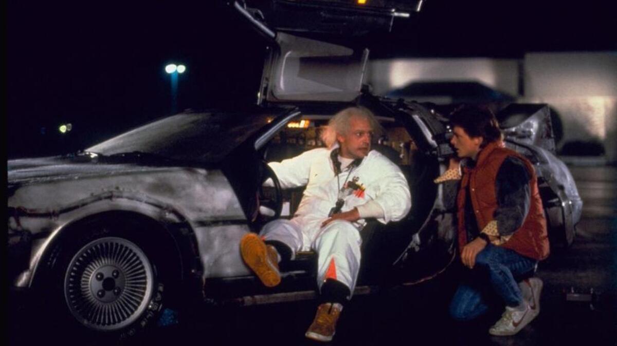 El inventor Emmett "Doc" Brown, interpretado por el actor Christopher Lloyd, izquierda, y Marty McFly, interpretado por Michael J. Fox, preparan la primera prueba de la máquina del tiempo en un estacionamiento, en la película de 1985 "Volver a la futuro ".