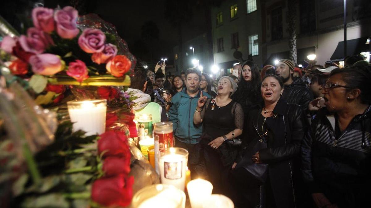 Cientos de personas lloran y cantan las canciones de Juan Gabriel al pie de su escultura el domingo 28 de agosto de 2016, en la Plaza Garibaldi en Ciudad de México (México).