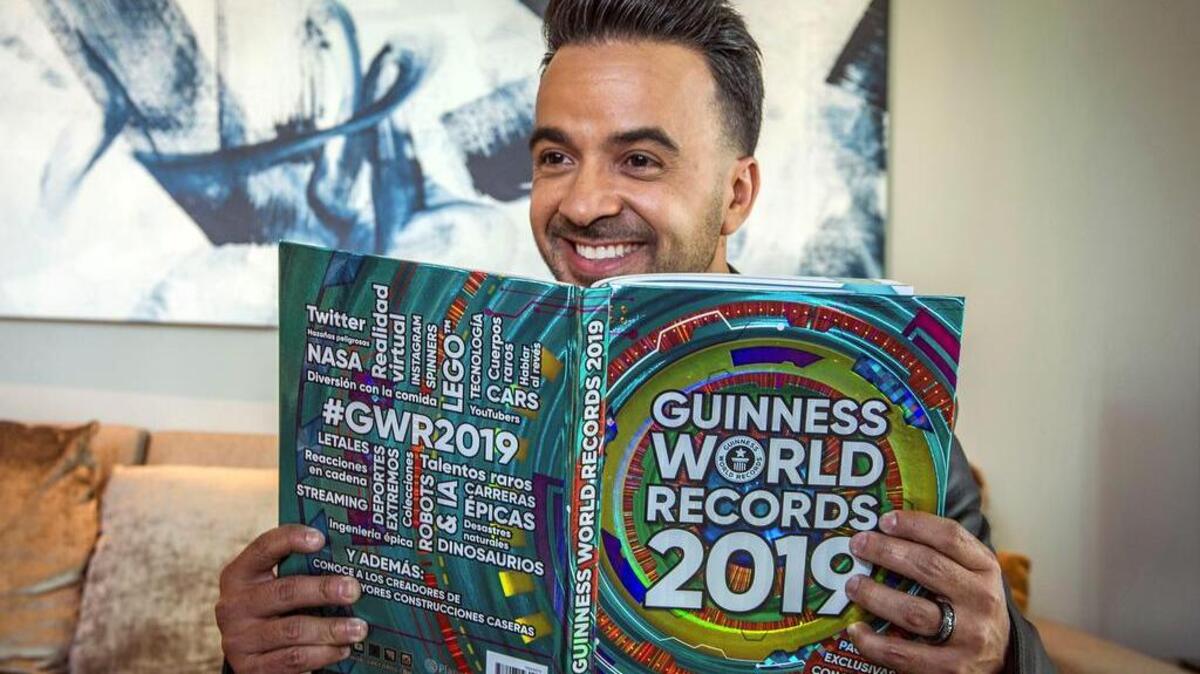 El cantautor puertorriqueño Luis Fonsi hojea el libro de los récords Guinness donde están incluidos los siete reconocimientos por su canción “Despacito”, durante un acto de reconocimiento celebrado el martes 16 de octubre de 2018, en Miami, Florida.