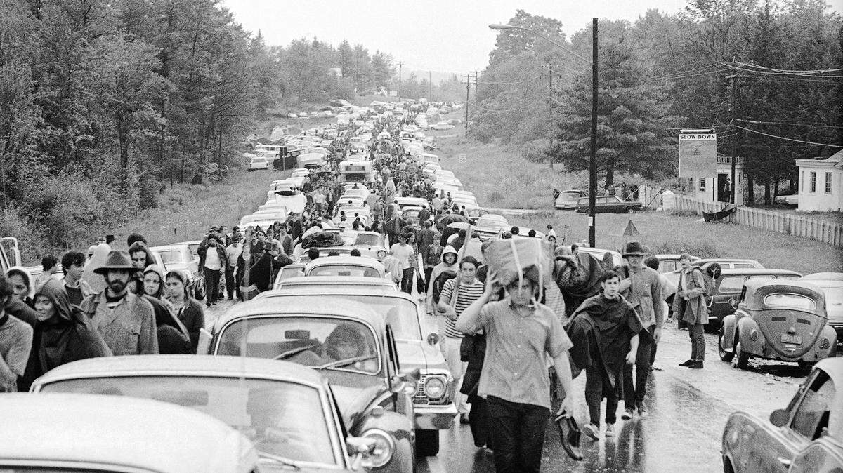 Cientos de personas caminan por una carretera tras la finalización del festival Woodstock, el 16 de agosto de 1969.