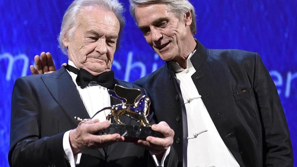 El director polaco Jerzy Skolimowski recibe el León de Oro por su trayectoria, de manos del actor británico Jeremy Irons (der.), durante la ceremonia de apertura de la 73 edición del Festival de Cine de Venecia.