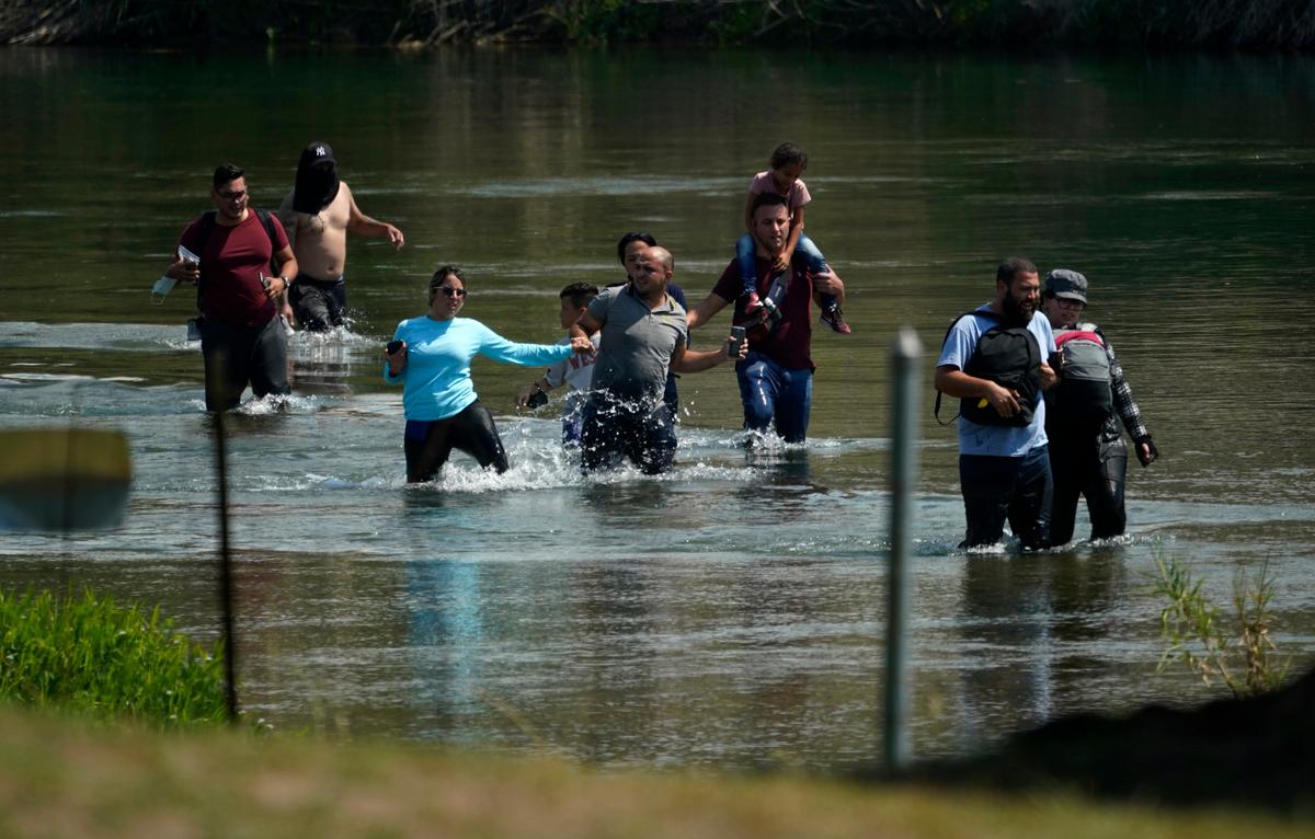 Un grupo de migrantes, principalmente de Venezuela, vadea el río Bravo al cruzar la frontera entre Estados Unidos y México el miércoles 16 de junio de 2021 en Del Rio, Texas.