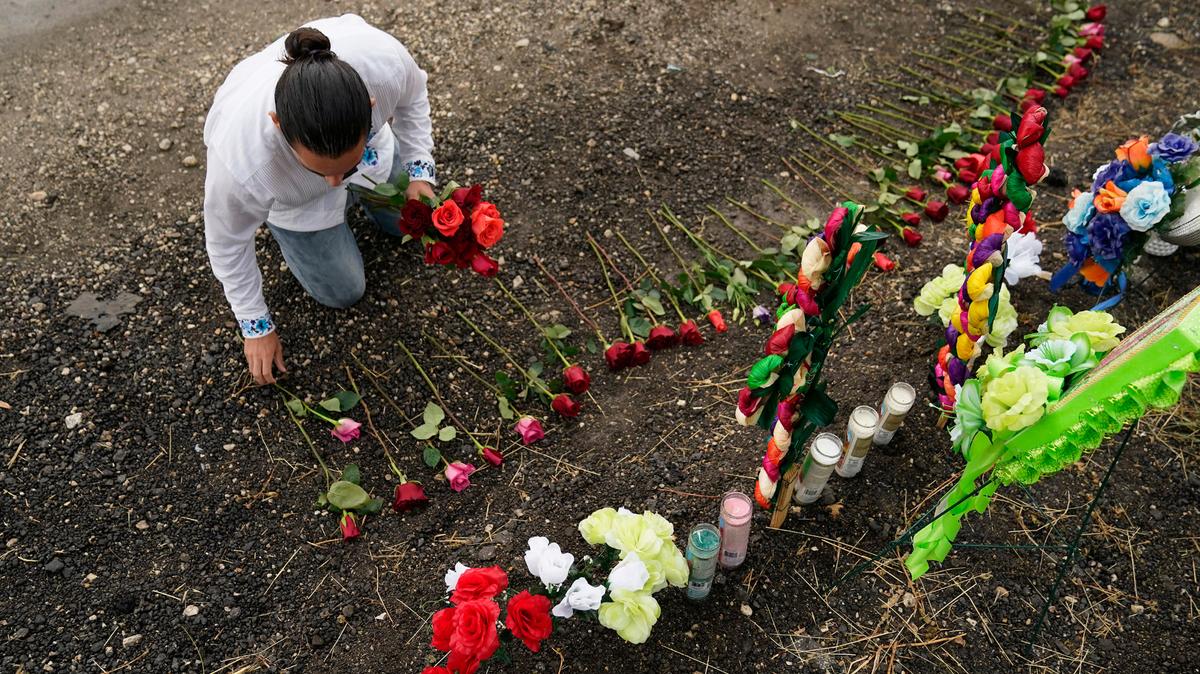 Carlow Eduardo Espina coloca el martes 28 de junio de 2022 unas rosas en un altar improvisado instalado en el lugar donde las autoridades estadounidenses encontraron a decenas de personas muertas dentro de un tractocamión en San Antonio, Texas. 