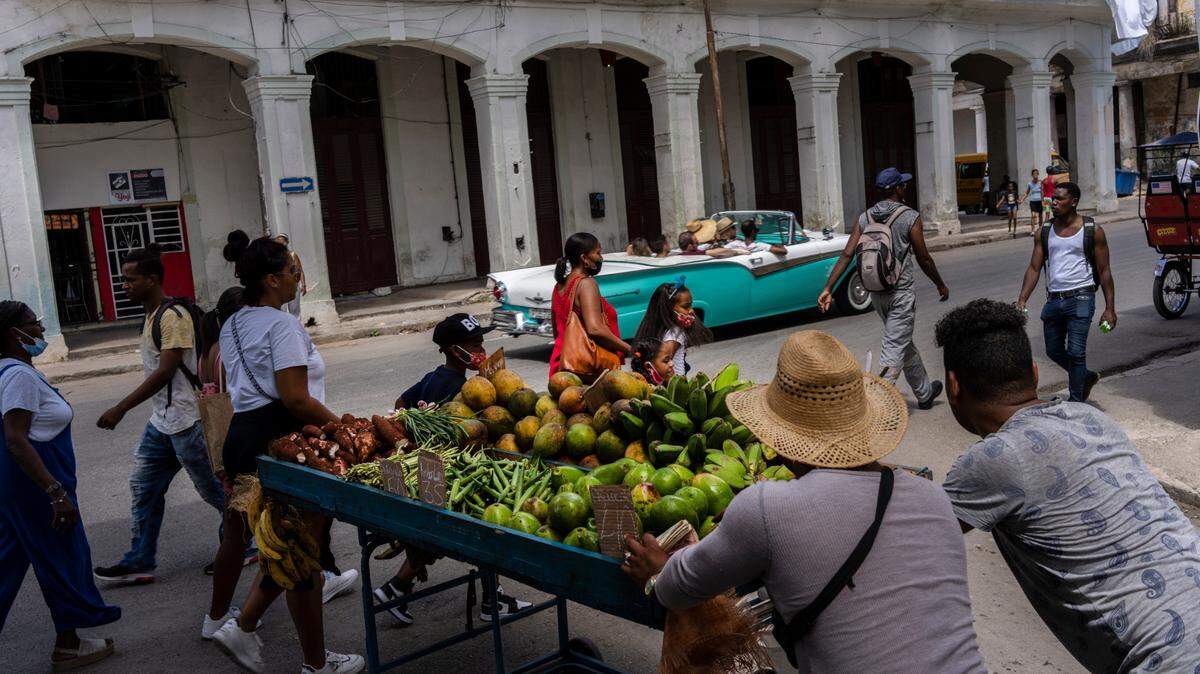 Dos vendedores ambulantes empujan su carrito con frutas y verduras el jueves 4 de agosto de 2022, en La Habana, Cuba. (AP Foto/Ramón Espinosa)